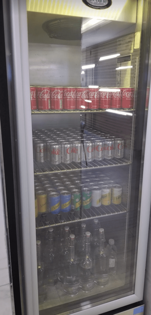 a refrigerator full of soda cans