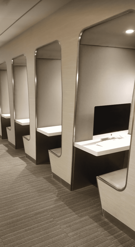 a row of white booths with a computer monitor