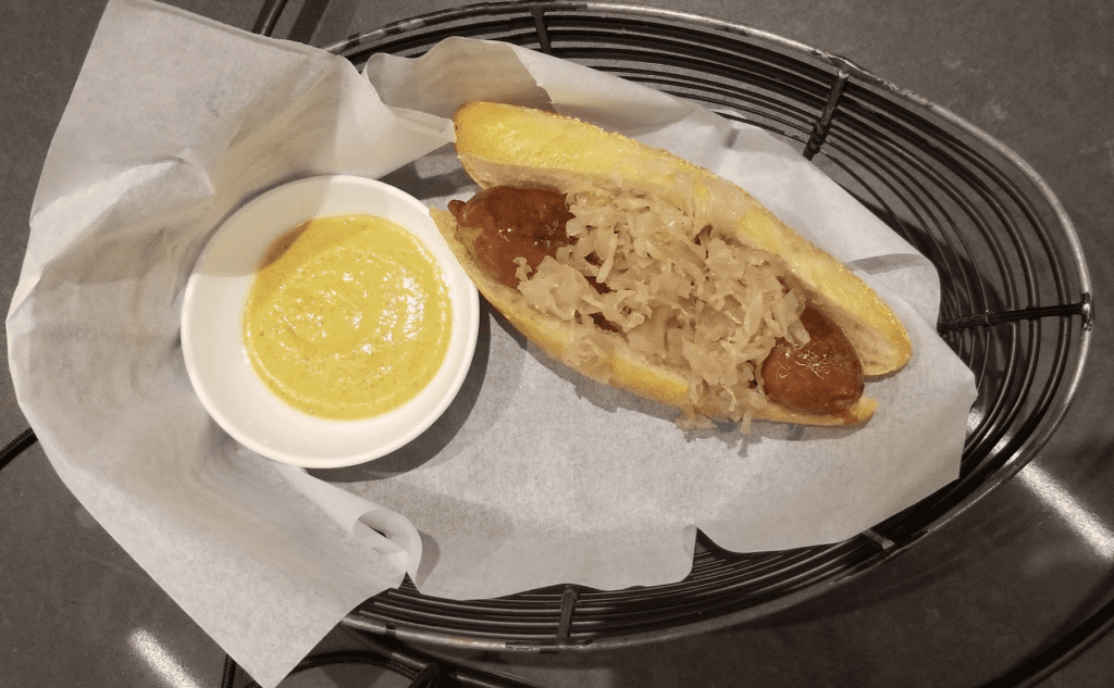 a hot dog with sauerkraut and sauce