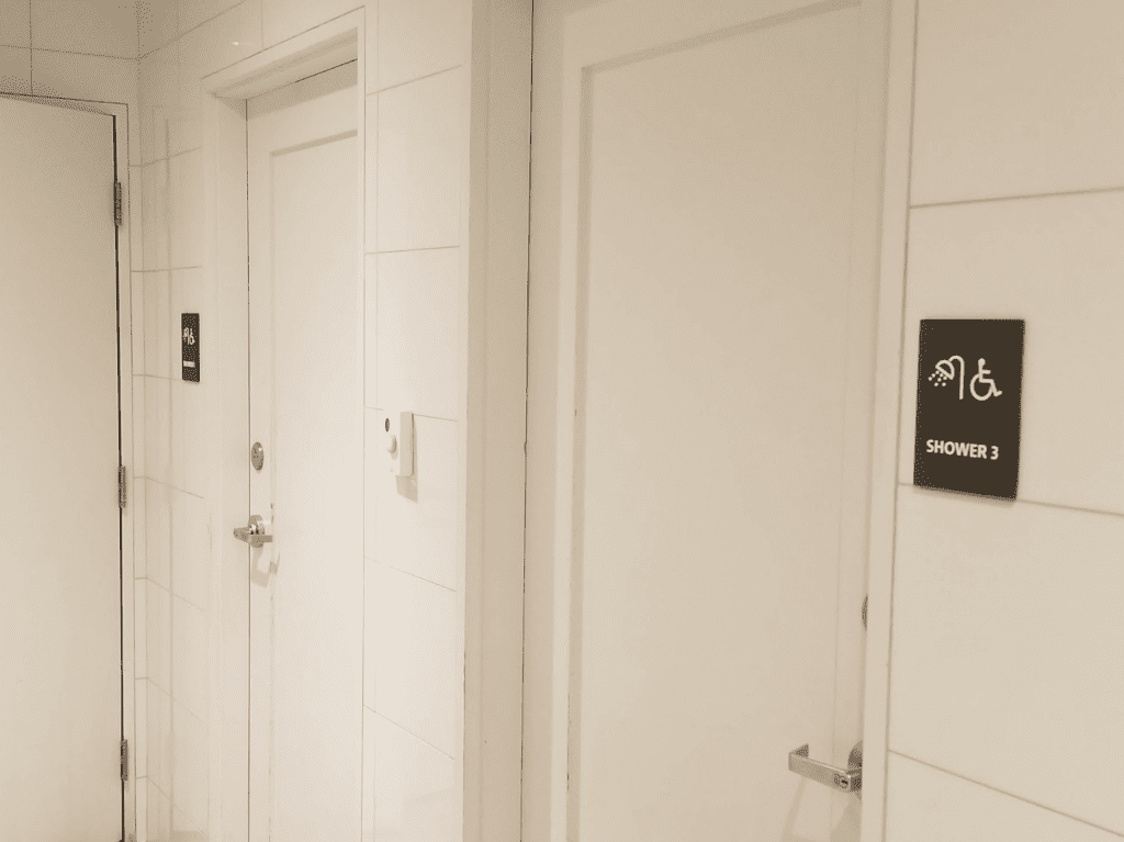 a white bathroom with a door and a sign