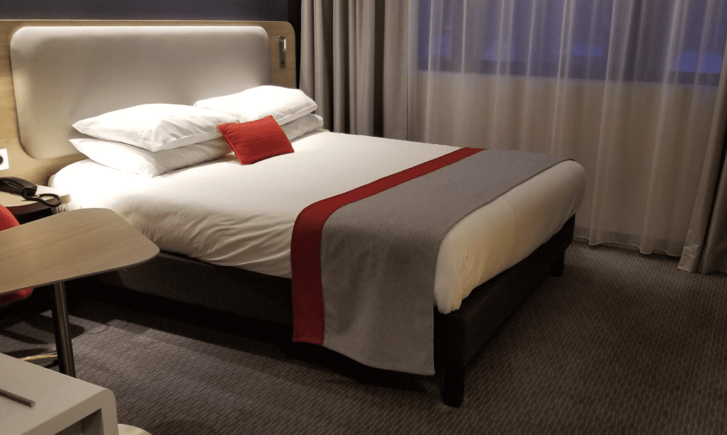 a bed with a red pillow