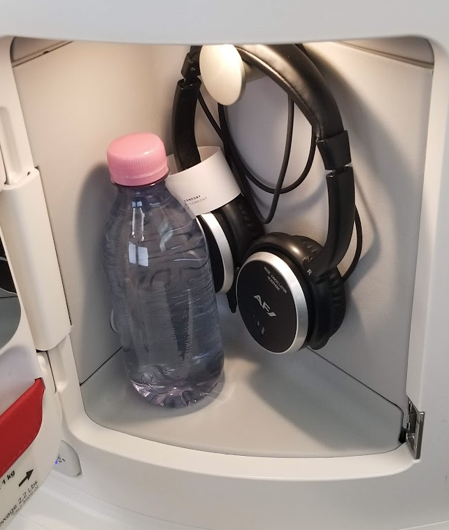 a bottle of water and headphones in a shelf