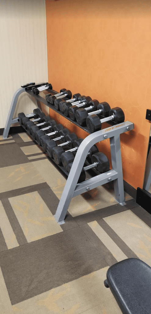 a rack of dumbbells on a carpeted floor