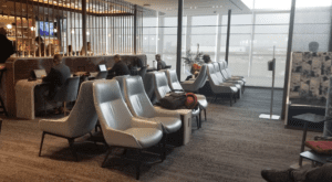a group of people sitting in chairs in a room with windows