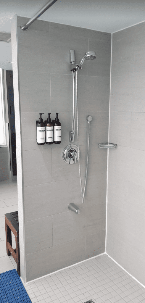 a shower with soap bottles and a shower head