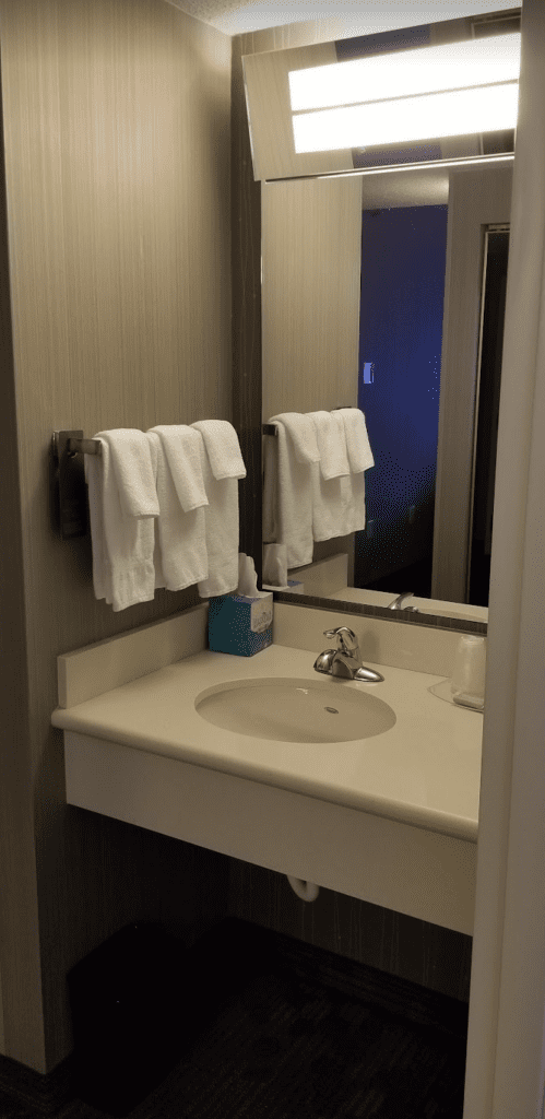 a bathroom sink with white towels on a rack