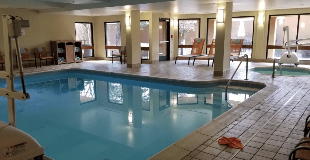 a swimming pool with chairs and a towel