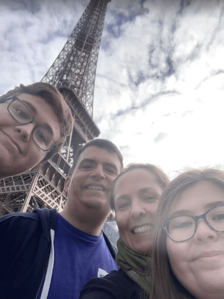 a group of people taking a selfie in front of a metal tower