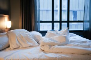 a bed with white sheets and pillows