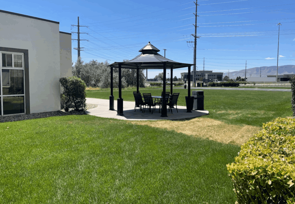 a gazebo with a table and chairs in a grassy area