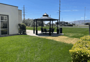 a gazebo with a table and chairs in a grassy area