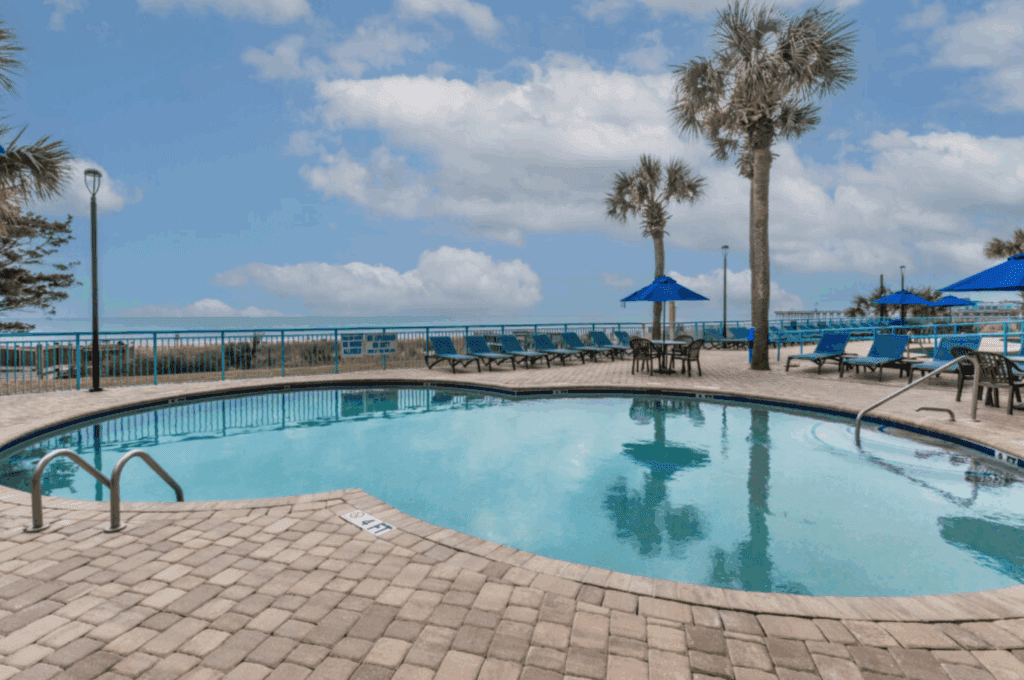 a pool with lounge chairs and umbrellas