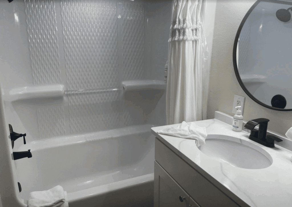 a bathroom with a round mirror and a bathtub