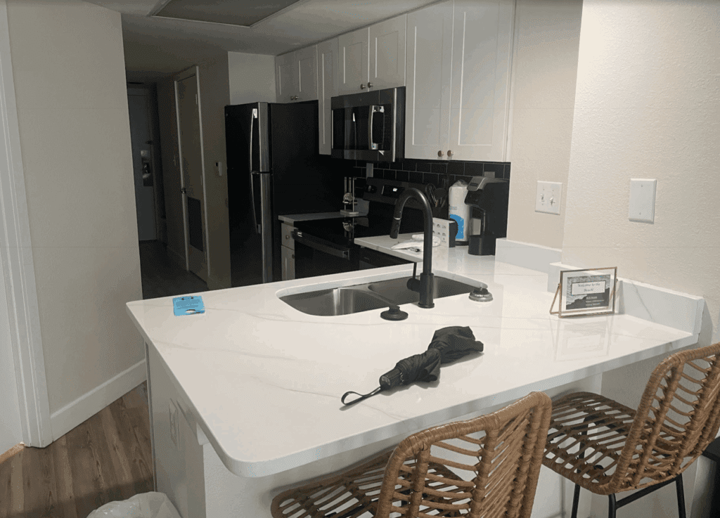 a kitchen with a sink and chairs