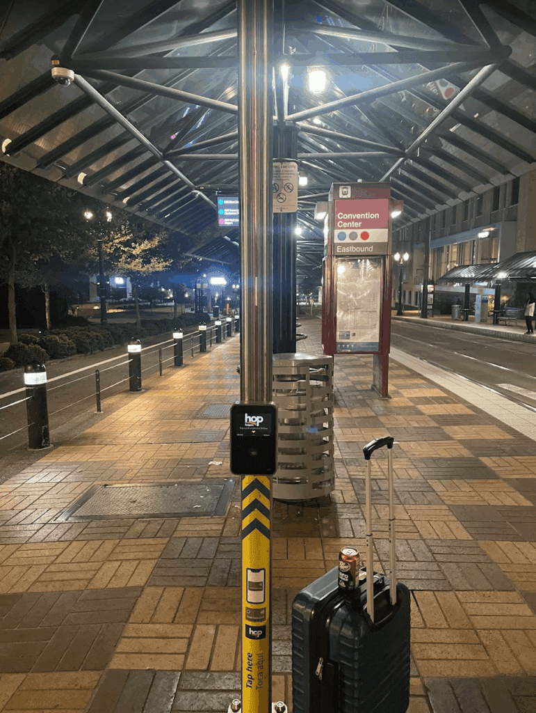 a bus stop with a luggage bag and a pole