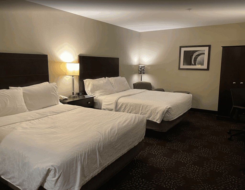 a room with two beds and a lamp