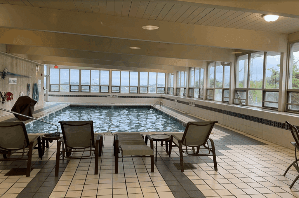 a indoor pool with chairs and a table