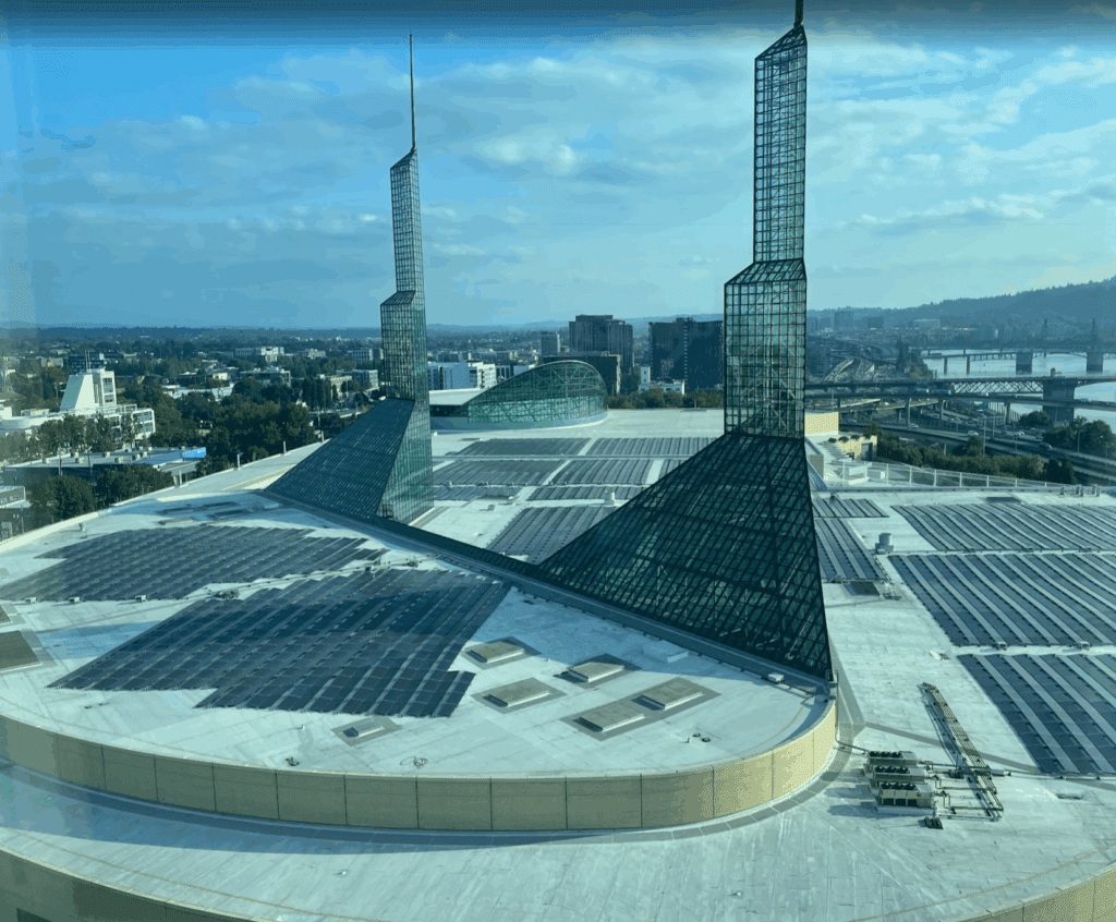 a large building with glass walls and a city in the background