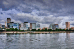 a city skyline with trees and water