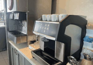 a coffee machine with white cups on top