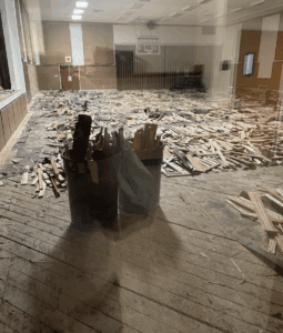 a room with a basketball hoop and trash can