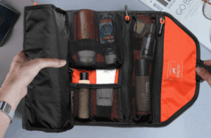 a hand holding a black and orange bag with a small black mesh inside