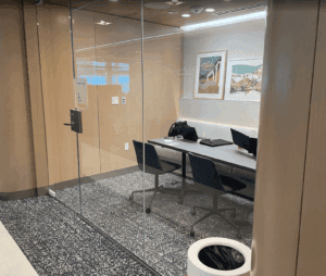 a glass wall with a desk and chairs