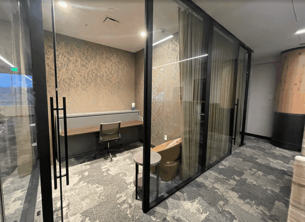 a glass wall with a desk and chair