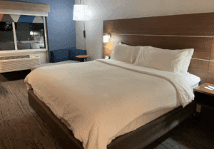 a bed with white sheets and a wood headboard