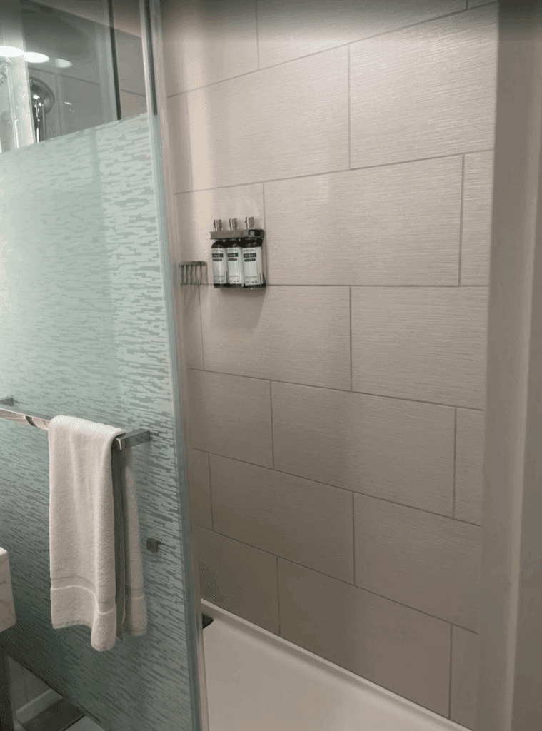 a shower with a towel and a rack