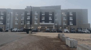 a building with many windows and cars parked in front of it