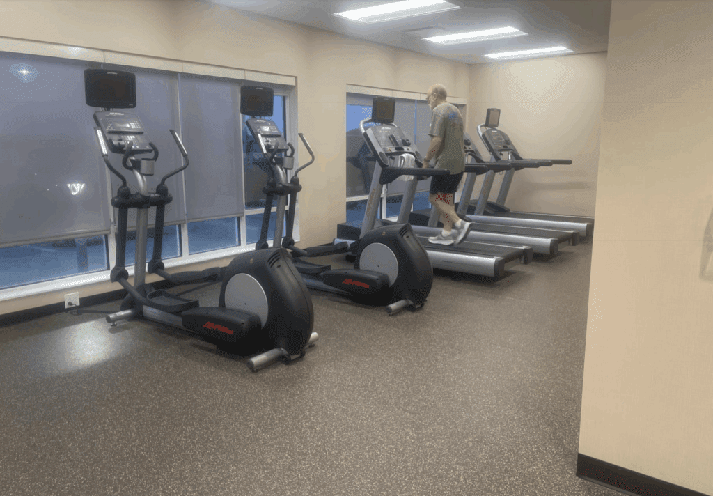 a man walking on treadmills in a gym