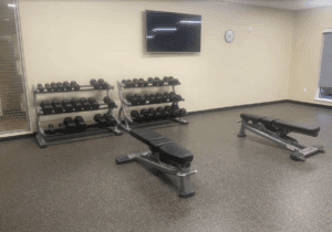 a gym with weights and a television on the wall