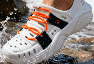 a person's foot in a white shoe with orange laces