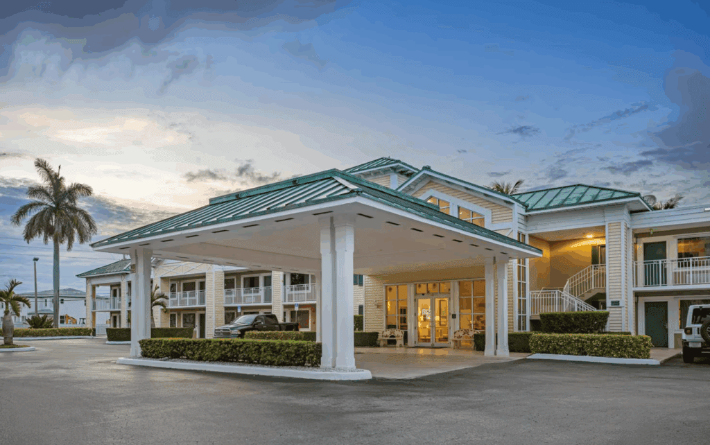 a building with a green roof and a car parked in front of it