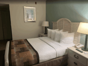 a bed with white pillows and a lamp in a room
