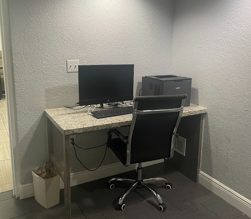 a desk with a computer and a chair