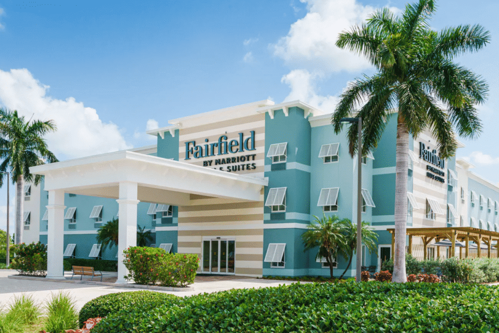 a building with palm trees and a sign
