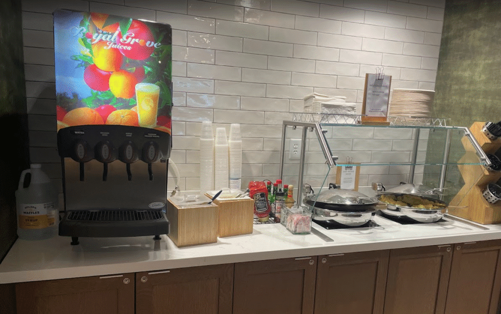 a counter with a drink dispenser and a pan