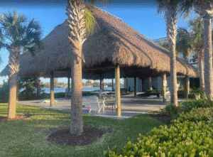 a building with grass roof and trees