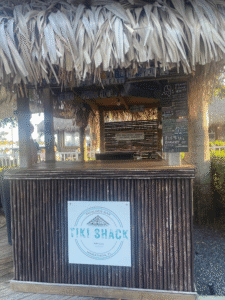 a tiki shack with a sign