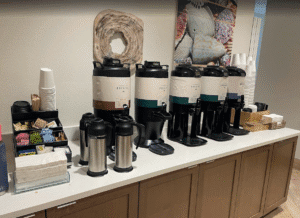 a coffee maker and coffee containers on a counter