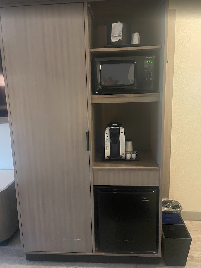 a cabinet with a microwave and coffee maker