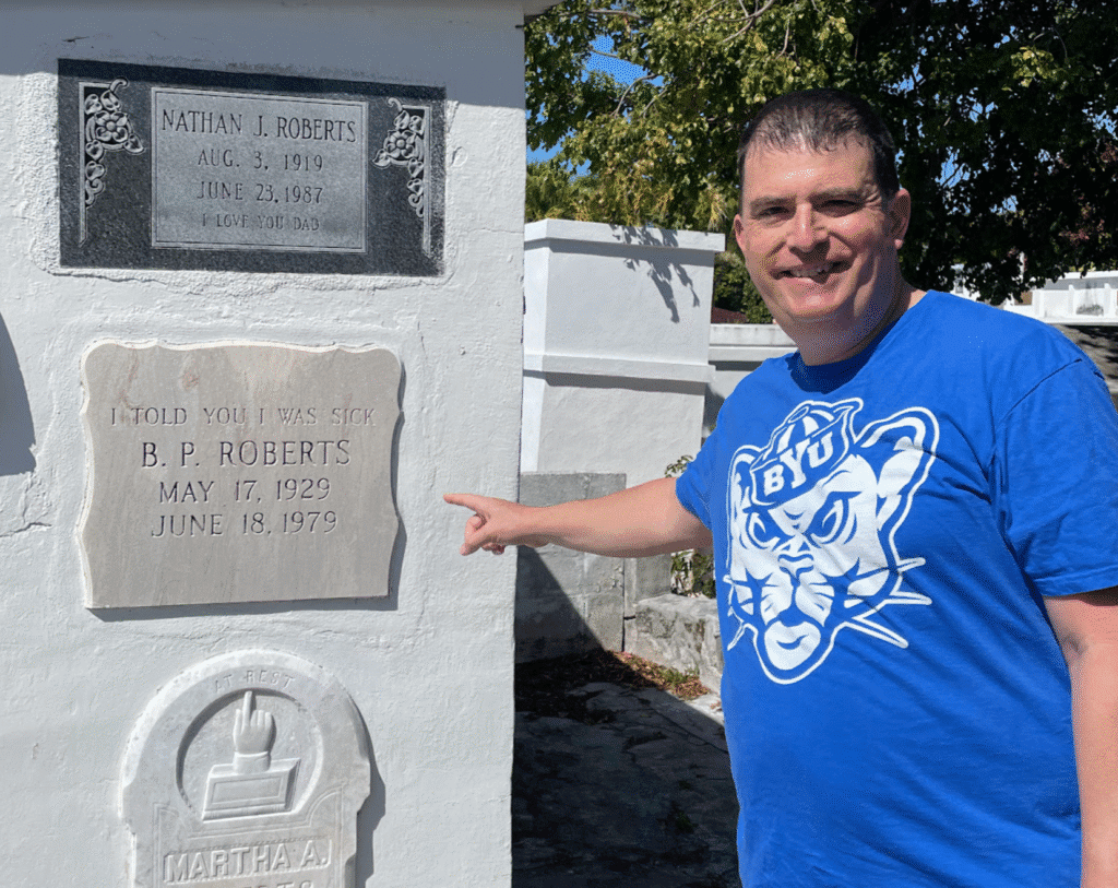 a man pointing at a grave stone