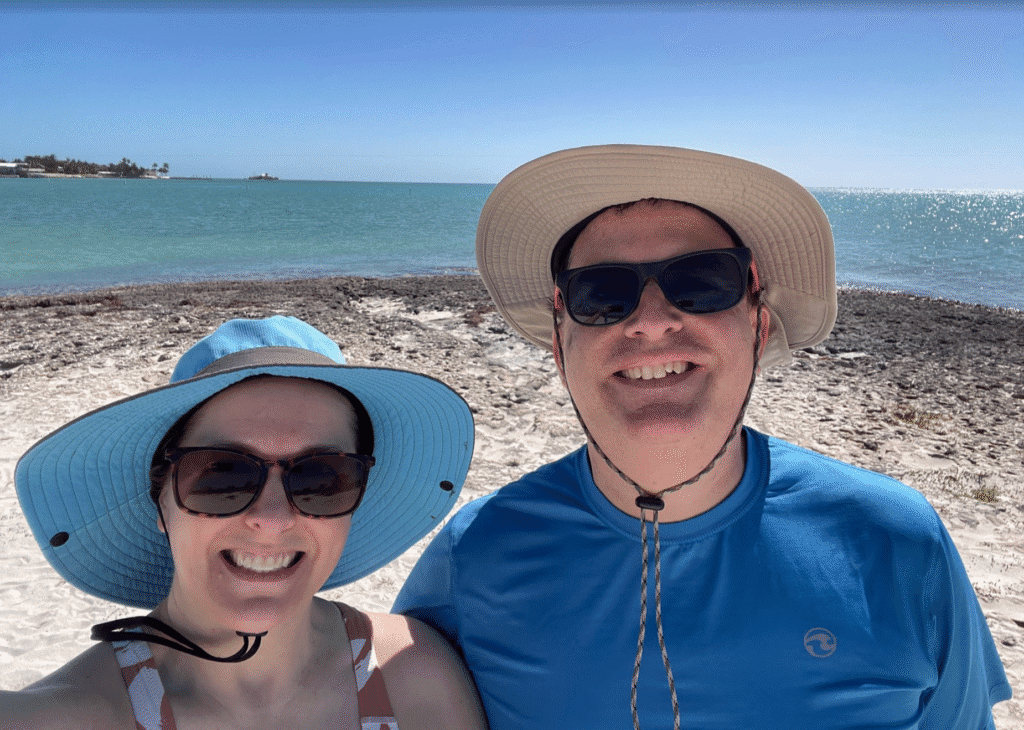 a man and woman taking a selfie on a beach