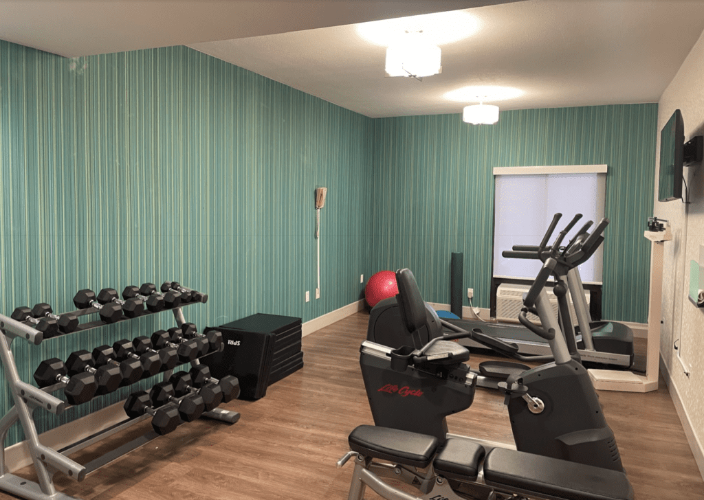 a room with exercise equipment and a wallpaper