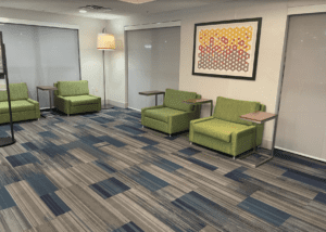 a room with green chairs and a painting on the wall