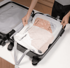 a person putting a white shirt in a suitcase