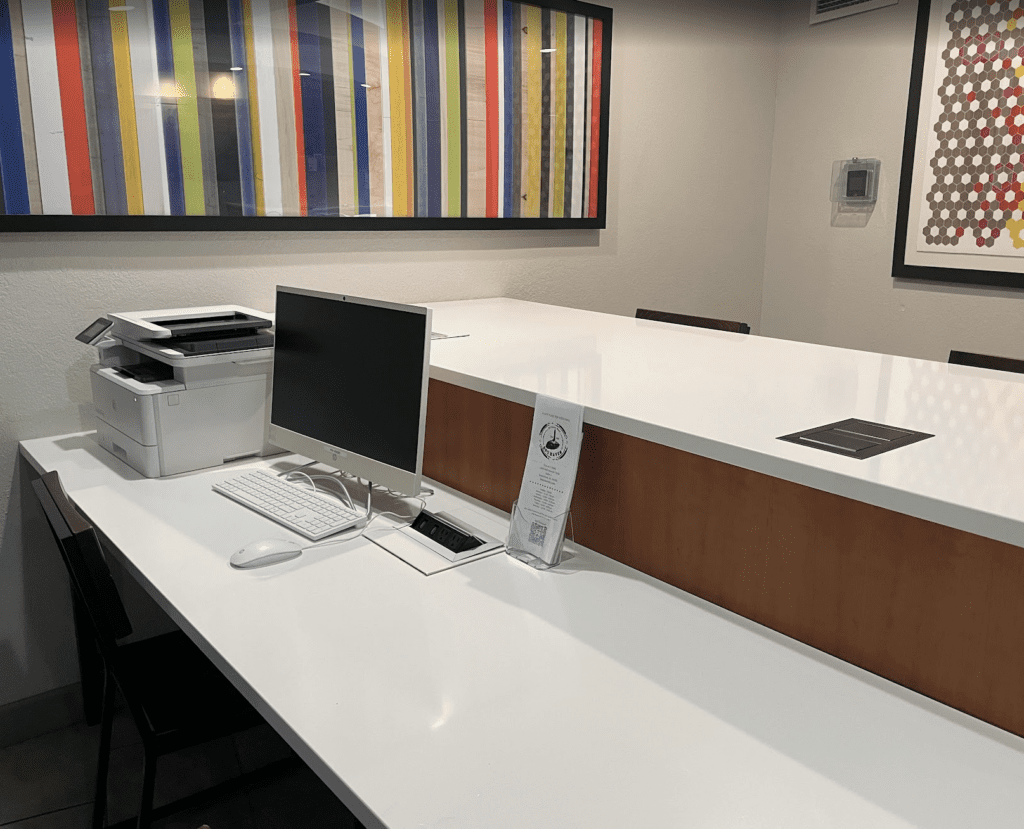 a white desk with a computer and printer