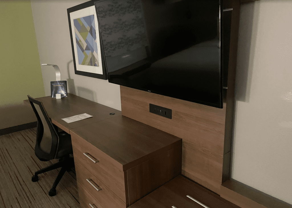 a desk with a tv and a picture on the wall